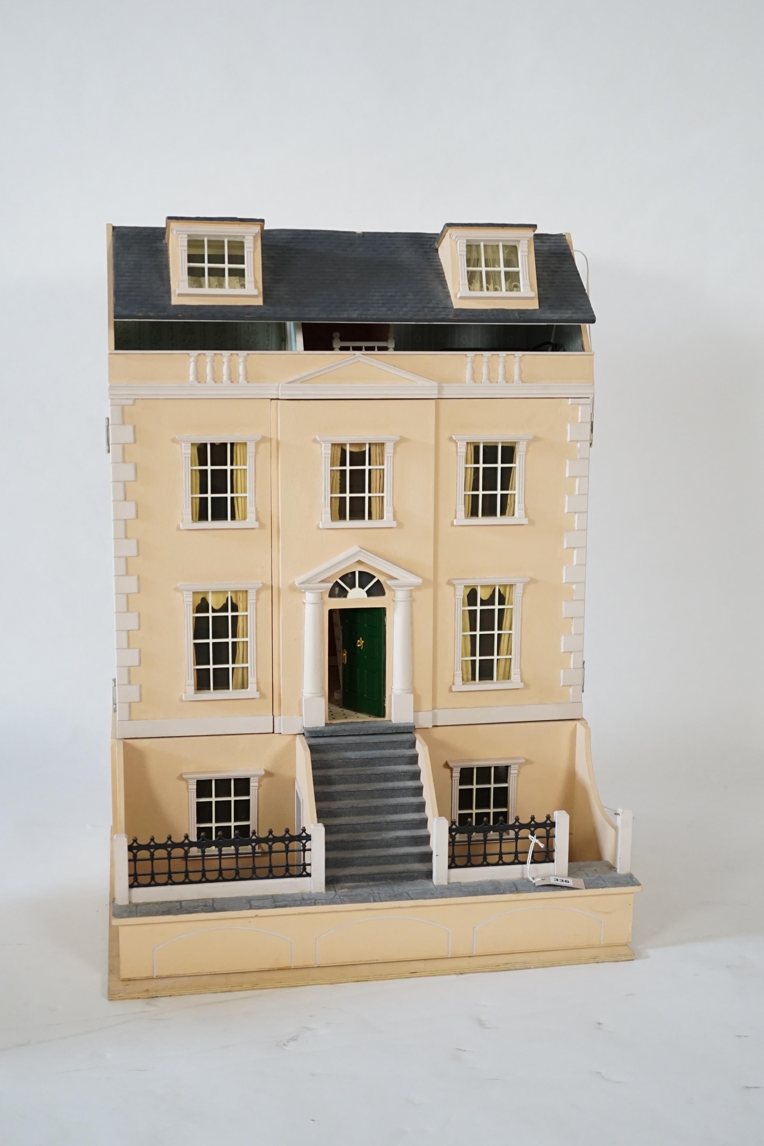 A large modern Georgian style dolls house and extensive contents, with eight fully decorated rooms on four floors, and fitted with electric lighting, removable front steps and pavement section to access basement rooms, 1